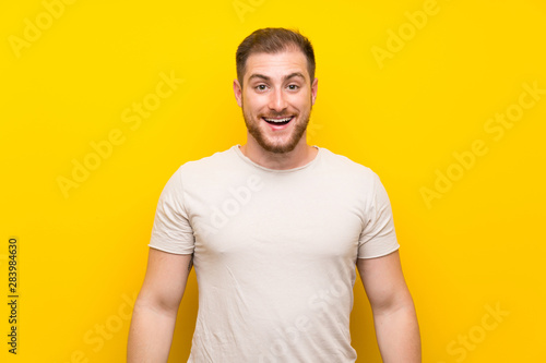 Handsome man over yellow background with surprise facial expression © luismolinero