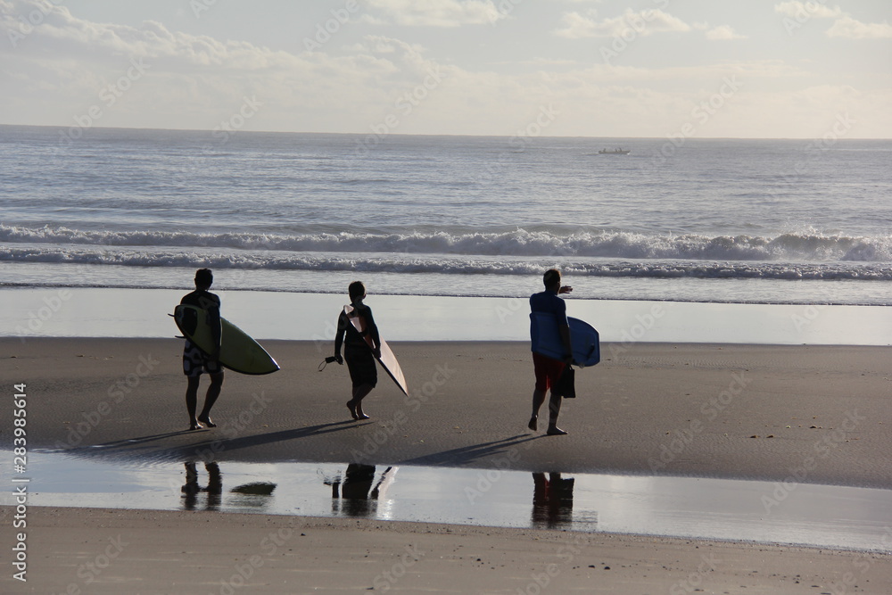 three surfers