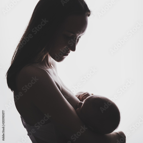 Картината върху платно Authentic silhouette of a young woman with a newborn baby in her arms breastfeed