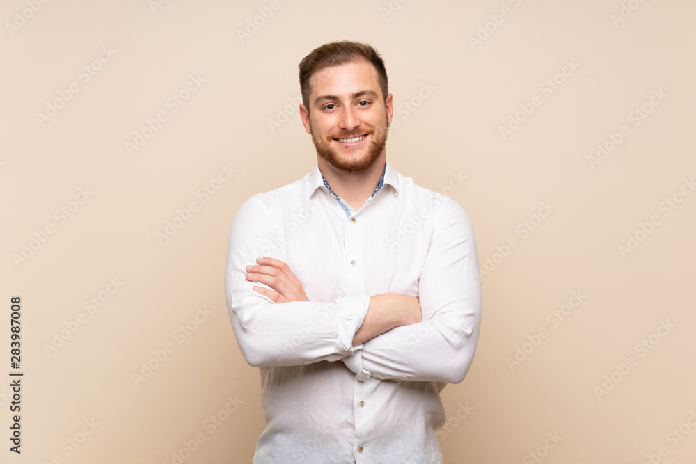 Blonde man over isolated background keeping the arms crossed in frontal position Blonde man over isolated background keeping the arms crossed in frontal position