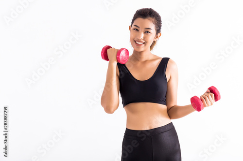 Young Asian woman in crop top practicing with dumbbells during workout and looking at camera on white background. Female fitness model training with barbells