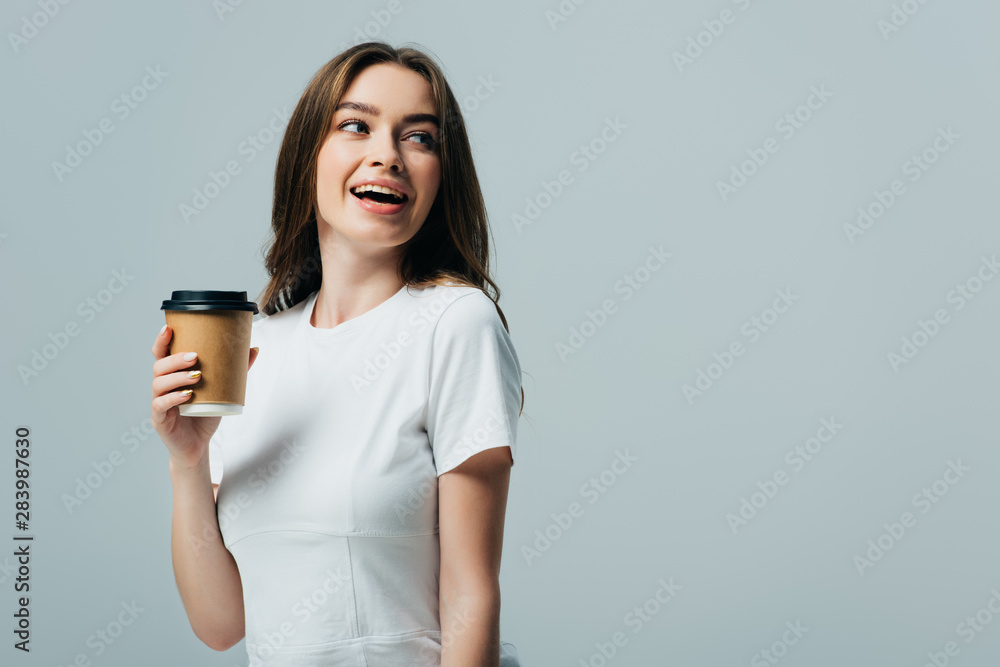 happy beautiful girl in white t-shirt with paper cup looking away isolated on grey happy beautiful girl in white t-shirt with paper cup looking away isolated on grey