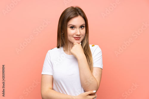 Teenager girl over isolated pink wall laughing