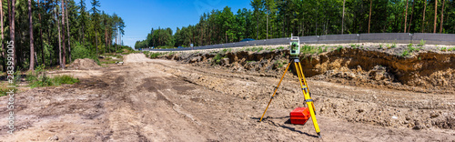Panoramic view of surveyor equipment (theodolite or total positioning station) on the construction site of the motorway, highway or road