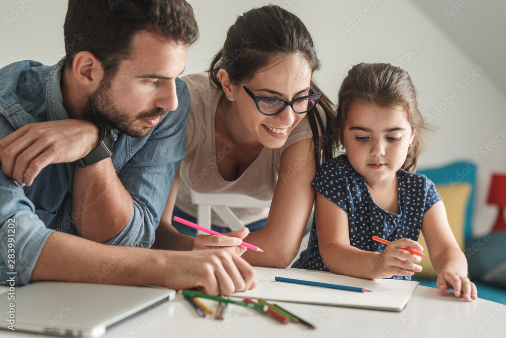 Father and mother teach daughter to draw.They sitting in living room.Education and family concept. Father and mother teach daughter to draw.They sitting in living room.Education and family concept.
