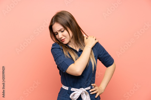Teenager girl over isolated pink background suffering from pain in shoulder for having made an effort