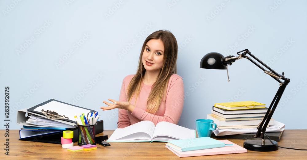 Teenager student girl in her room extending hands to the side for inviting to come Teenager student girl in her room extending hands to the side for inviting to come