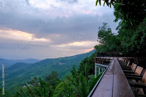 viewing area on the mountain with chairs for relaxation,view of green mountains and cloudy sky