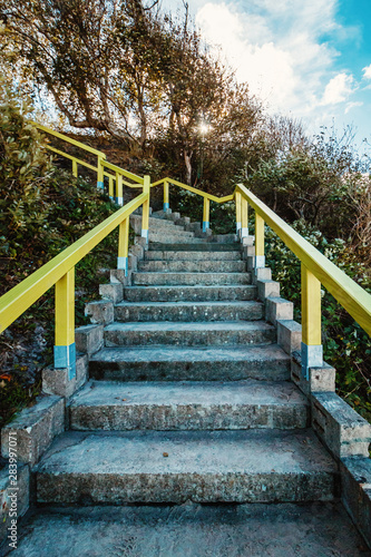 Stair case with yellow railing on a beach at the Baltic Sea on the German island of Rügen right before sunset