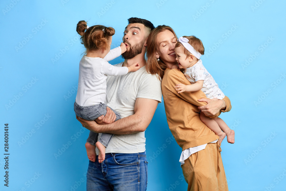 naughty children tormenting their parents, teasing dad and mommy. close up photo. crazy kids don't obey their parents. isolated blue background - obrazy, fototapety, plakaty 