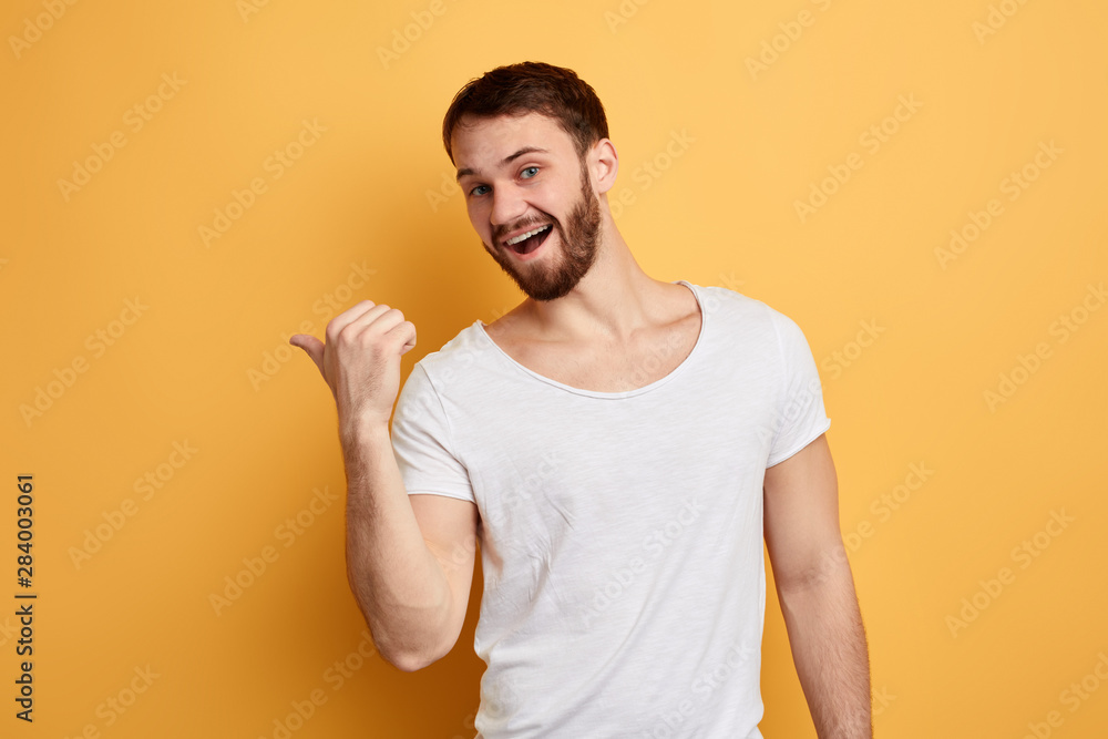 funny emotional positive man showing with thumb aside, isolated yellow background. studio shot. close up photo.place for text, advertisement. copy space funny emotional positive man showing with thumb aside, isolated yellow background. studio shot. close up photo.place for text, advertisement. copy space