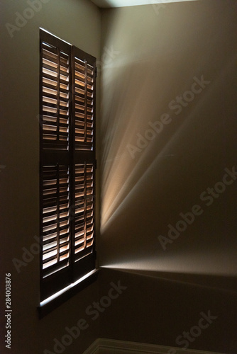 sunbeams streaming through wooden shutters