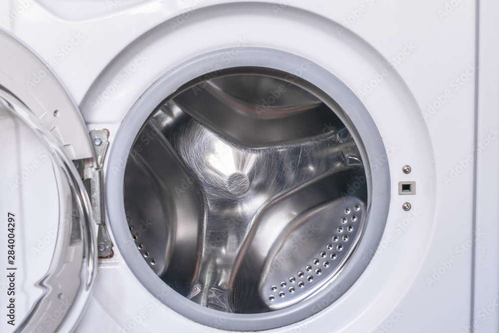The open door of the washing machine is a close-up. Empty drum washer The open door of the washing machine is a close-up. Empty drum washer