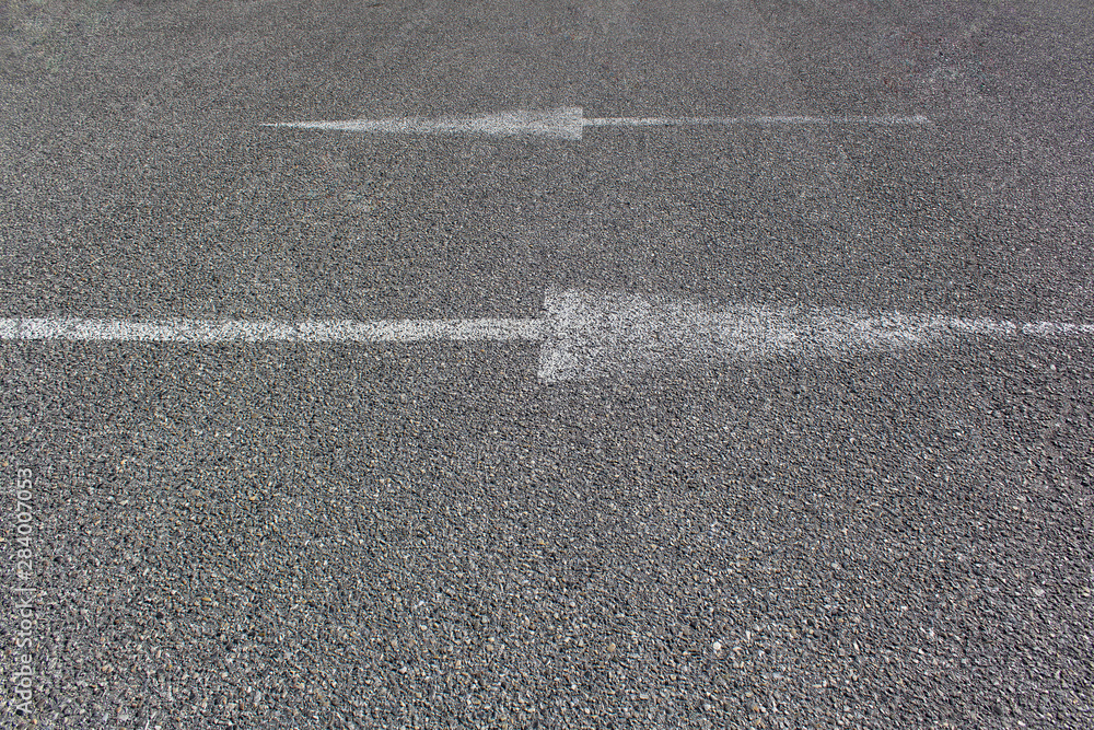 asphalt rod background texture with white arrow opposite way direction