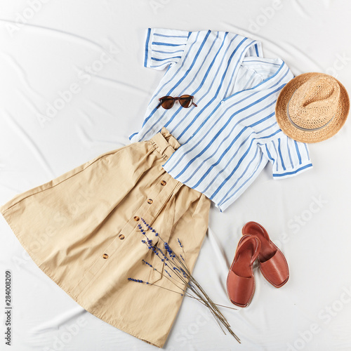 white stried shirt, brown skirt, straw boater hat, straw hat,on white background. Woman's casual outfit. Flat lay, top view. Trendy simple basic minimalistic look. photo