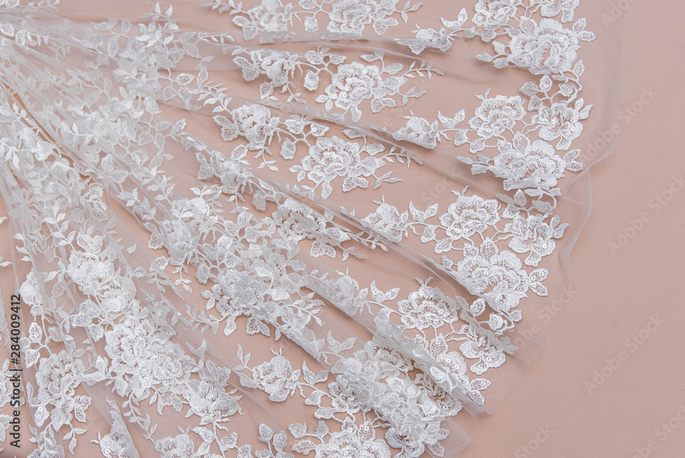 Texture lace fabric. lace on white background studio. thin fabric made of yarn or thread. a background image of ivory-colored lace cloth. White lace on beige background.