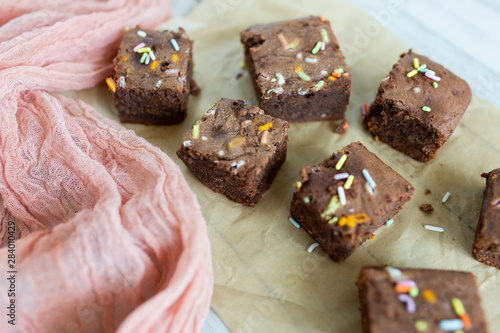 Banana brownies with multi colored sprinkles, crinkled parchment paper, pink raw silk fabric