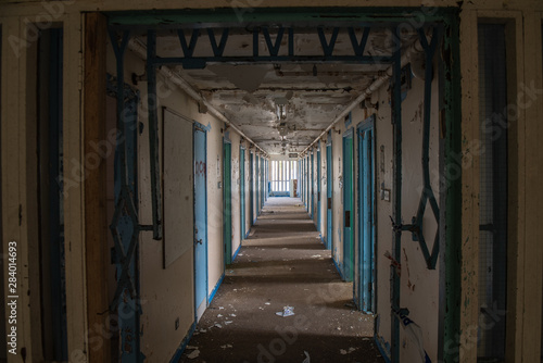 Corridor of prison cell doors inside an abandoned prison.