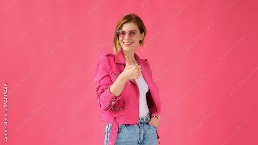 Thumb up. Woman shows like and approval on pink a pink background. Thumb up. Woman shows like and approval on pink a pink background.