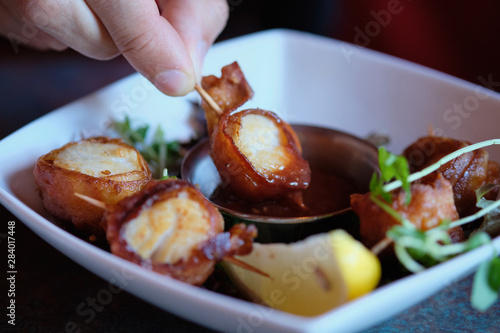 Scallops wrapped in bacon and slice of a lemon