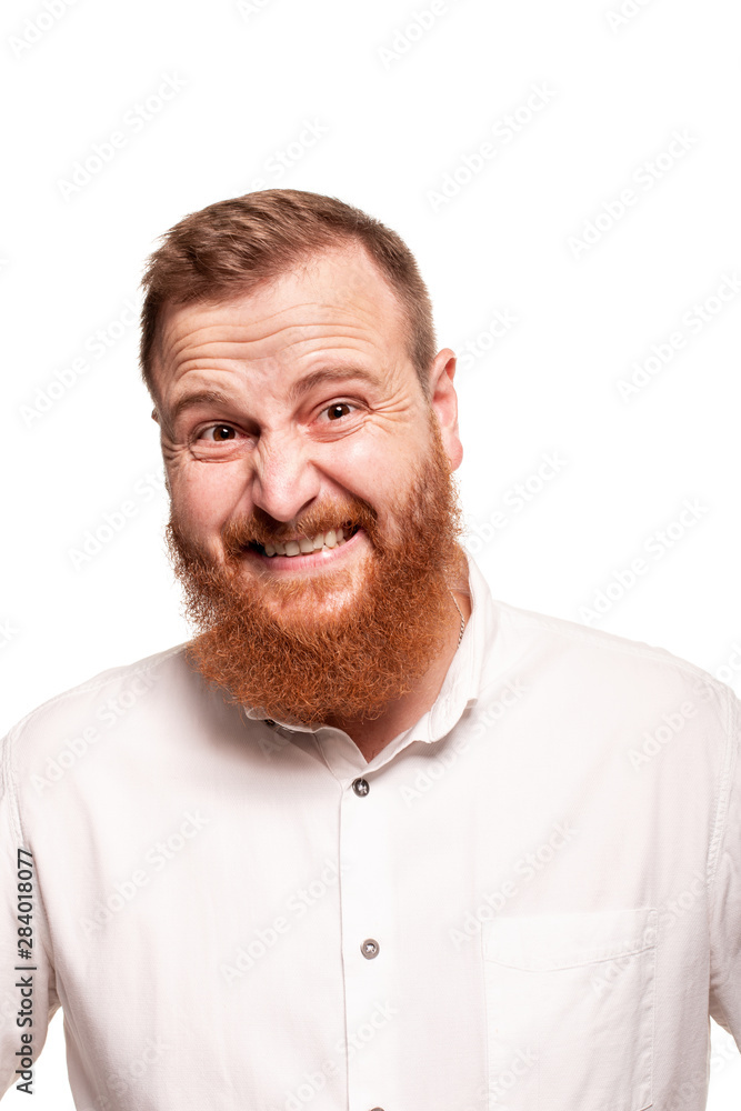 Portrait of a young, chubby, redheaded man in a white shirt making faces at the camera, isolated on a white background Portrait of a young, chubby, redheaded man in a white shirt making faces at the camera, isolated on a white background