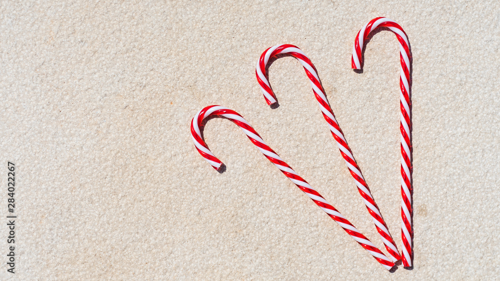 red candy canes on the white textured background. Christmas moody background. Copy space. Merry Christmas and Happy New Year! red candy canes on the white textured background. Christmas moody background. Copy space. Merry Christmas and Happy New Year!