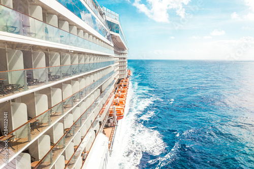 Billede på lærred Side view of cruise ship on the blue sky background with copy space, blue tone