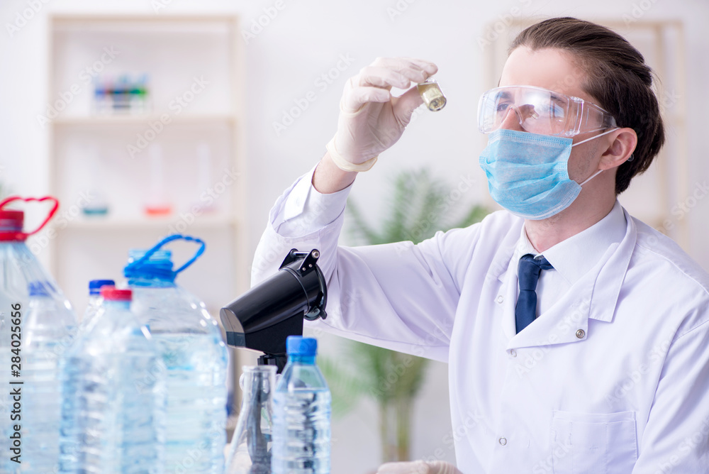 Fototapeta premium Young male chemist experimenting in lab