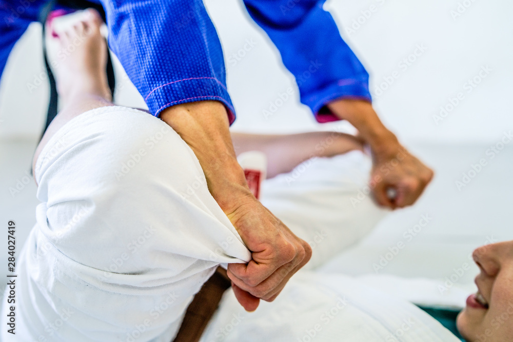 Grips from the guard in brazilian jiu jitsu bjj training sparring two female women athletes fighters drilling techniques for the competition closed guard holding kimono gi pass Grips from the guard in brazilian jiu jitsu bjj training sparring two female women athletes fighters drilling techniques for the competition closed guard holding kimono gi pass
