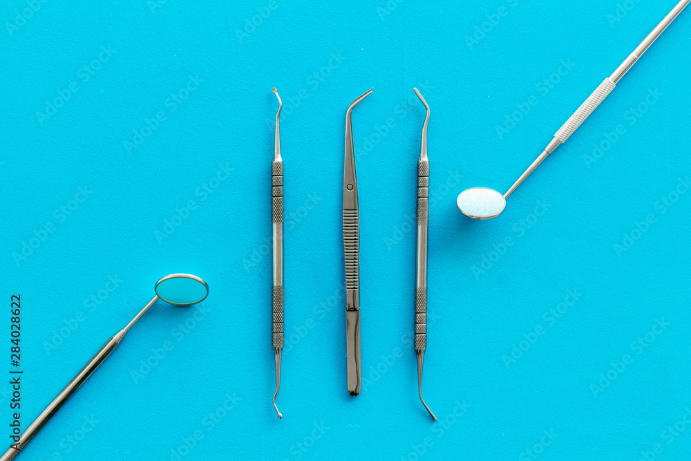 stomatologist instruments on blue doctor's office desk background top view