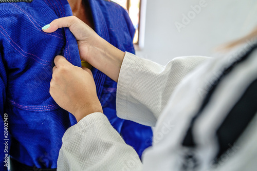 Judo BJJ brazilian Jiu jitsu grip female fighter gripping hold kimono gi lapel in a fight training sparring