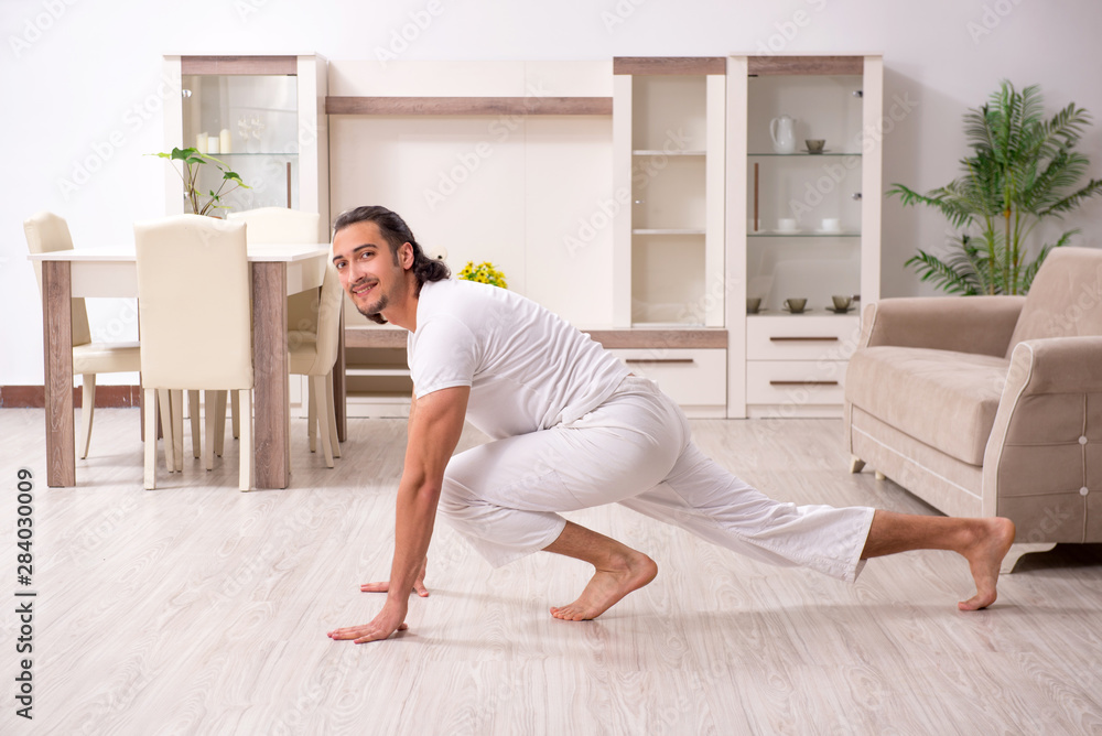 Young man doing physical exercises at home Young man doing physical exercises at home