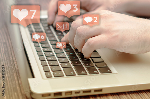 Person is using laptop with black keys, Social media and social networking. Marketing concept. Hearts and letterboxes with counters. Marketing and business concept. May be used for illustration.