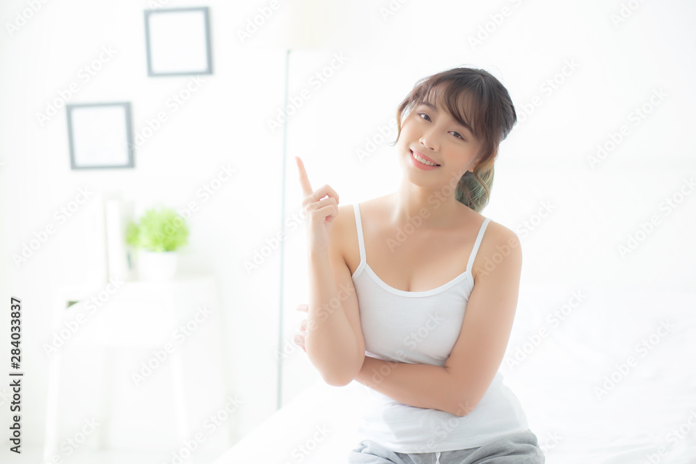 Beautiful portrait young asian woman smiling healthy and wellness at room, beauty asia girl having idea presenting and pointing something skin care and makeup cosmetic, lifestyle concept. Beautiful portrait young asian woman smiling healthy and wellness at room, beauty asia girl having idea presenting and pointing something skin care and makeup cosmetic, lifestyle concept.