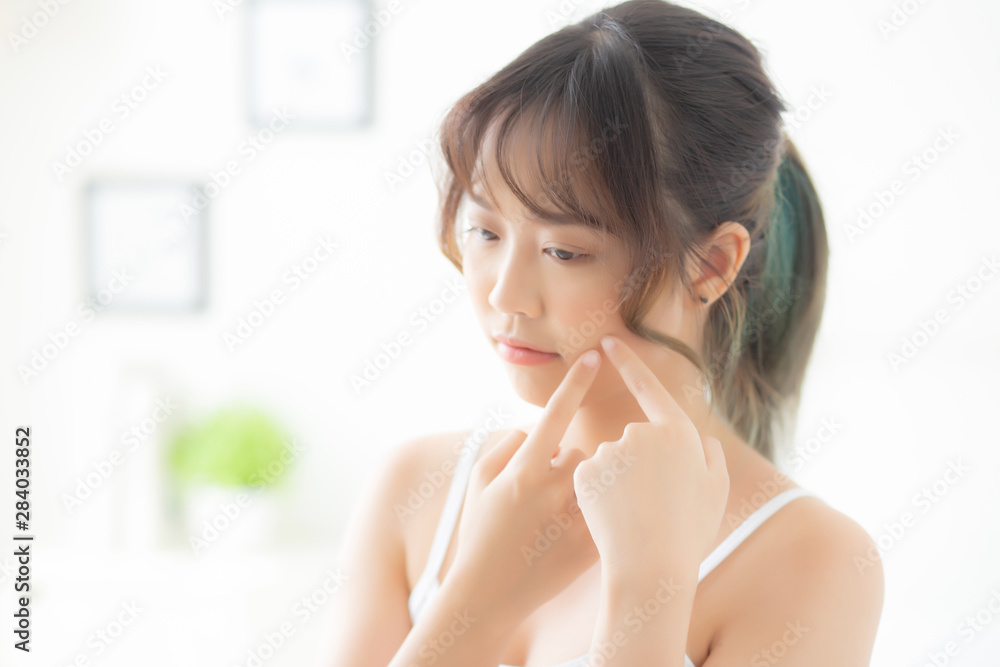 Beautiful portrait young asian woman with acne problem in the bedroom, trouble of beauty on face, zit treatment, asia girl is pimple having worry and displeased, skincare and healthy concept. Beautiful portrait young asian woman with acne problem in the bedroom, trouble of beauty on face, zit treatment, asia girl is pimple having worry and displeased, skincare and healthy concept.