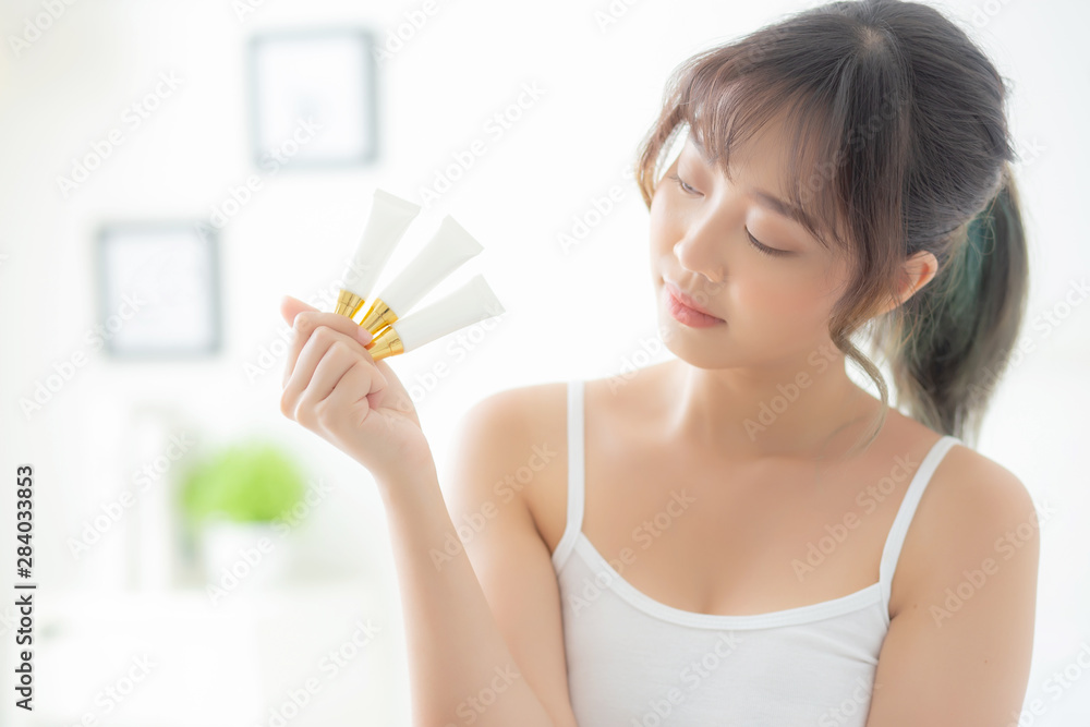 Beautiful portrait young asian woman holding and presenting cream or lotion product, beauty asia girl show cosmetic makeup and moisturizing for skin care, healthy care and wellness concept. Beautiful portrait young asian woman holding and presenting cream or lotion product, beauty asia girl show cosmetic makeup and moisturizing for skin care, healthy care and wellness concept.