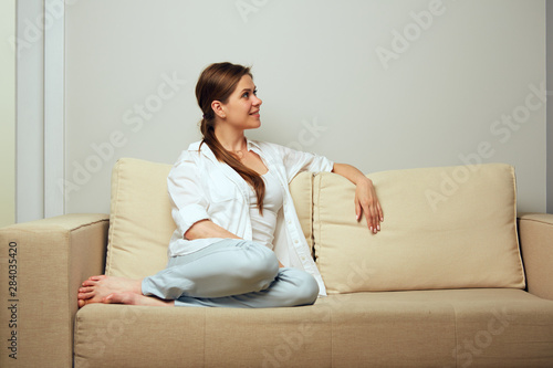 Smiling woman relax at home on couch.