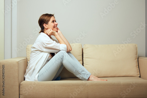 woman relaxing at home sitting on sofa.
