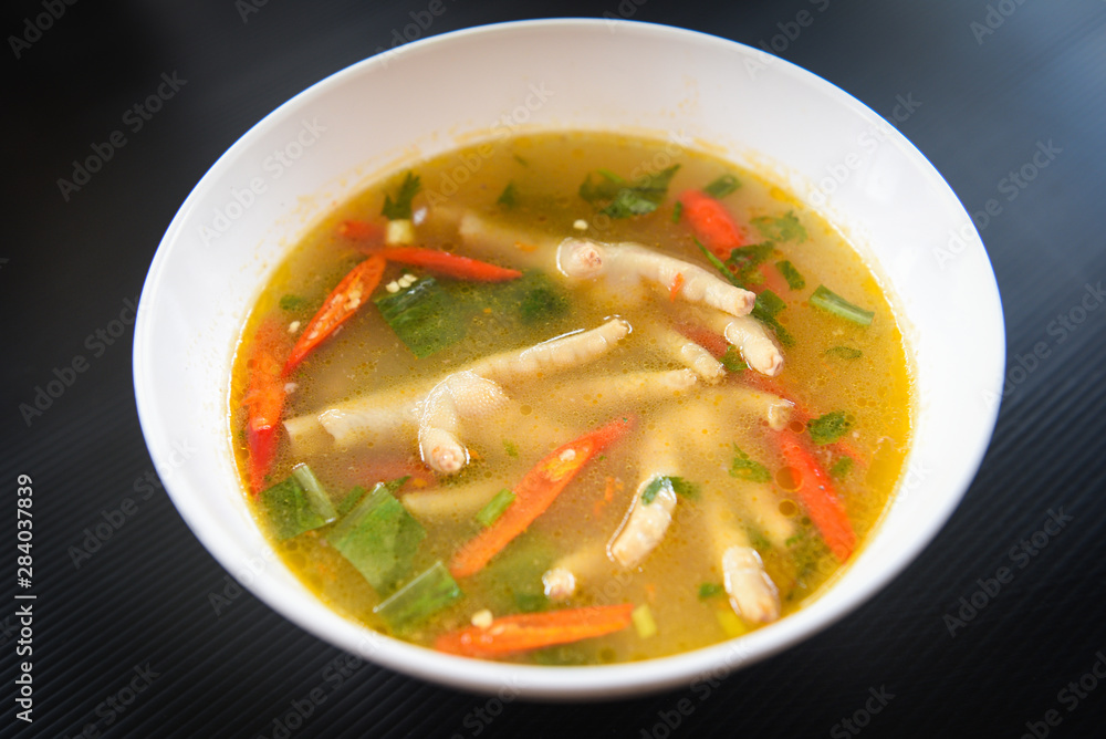 Chicken Feet Spicy Soup - Chicken Foot with hot and sour soup bowl with fresh vegetables Tom Yum thai herbs and spices ingredients , Thai Food Asian