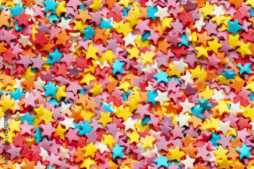 Sugar stars for baking decoration. Confectionery multi-colored topping closeup. Seamless background. You can create an endless picture
