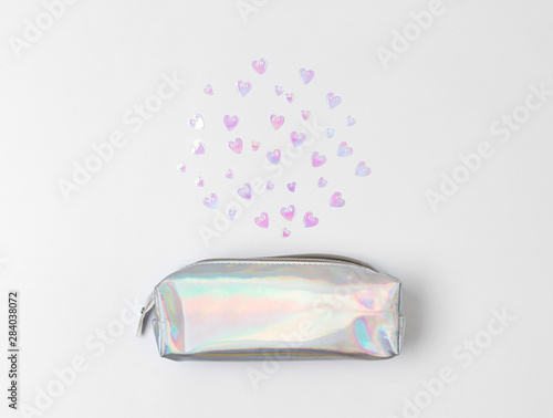 Obraz na plátně Holographic pencil case with heart confetti on white background