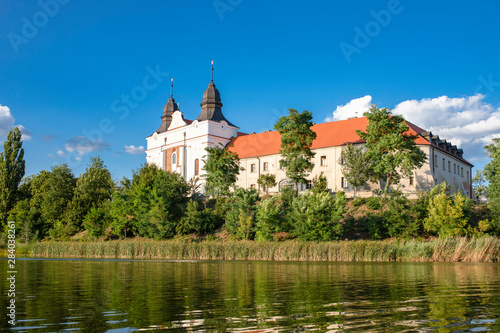 Church, former benedictine abbey in the village Mogilno / Poland. view from the lake - water reflection. photo