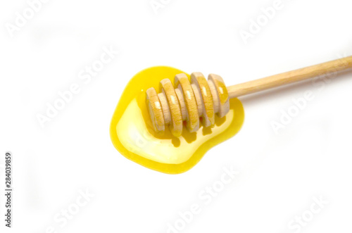 spoon for honey and liquid honey, selective focus white background