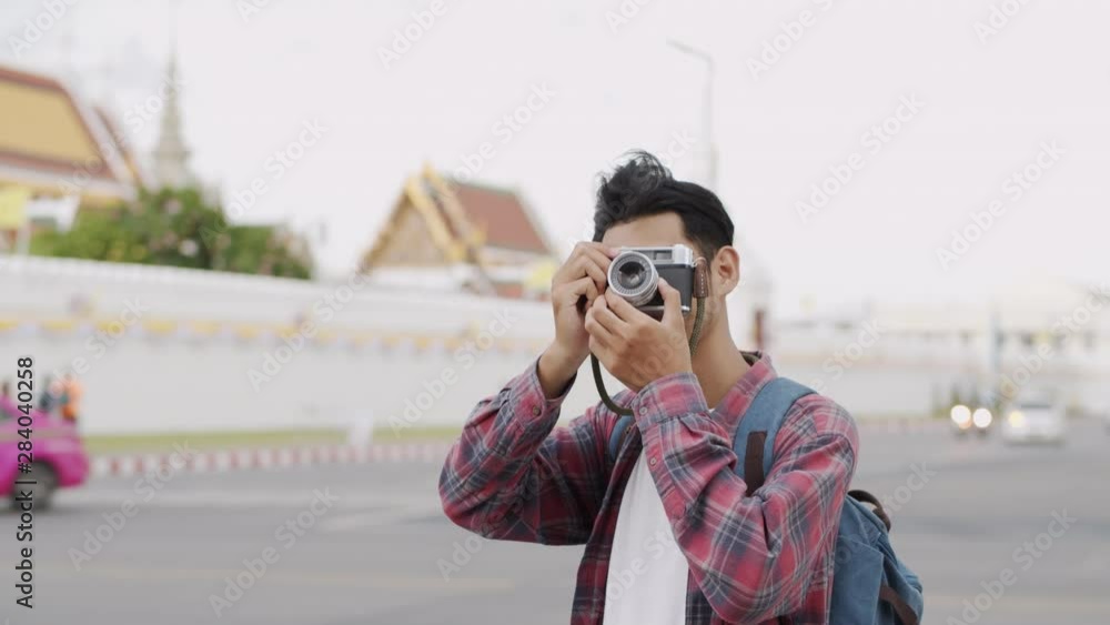 Asian man tourist taking photo with film camera at Bangkok Thailand in summer time, Solo travel and backpacker concept Asian man tourist taking photo with film camera at Bangkok Thailand in summer time, Solo travel and backpacker concept
