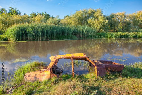 rusty car frame in the swamp water 