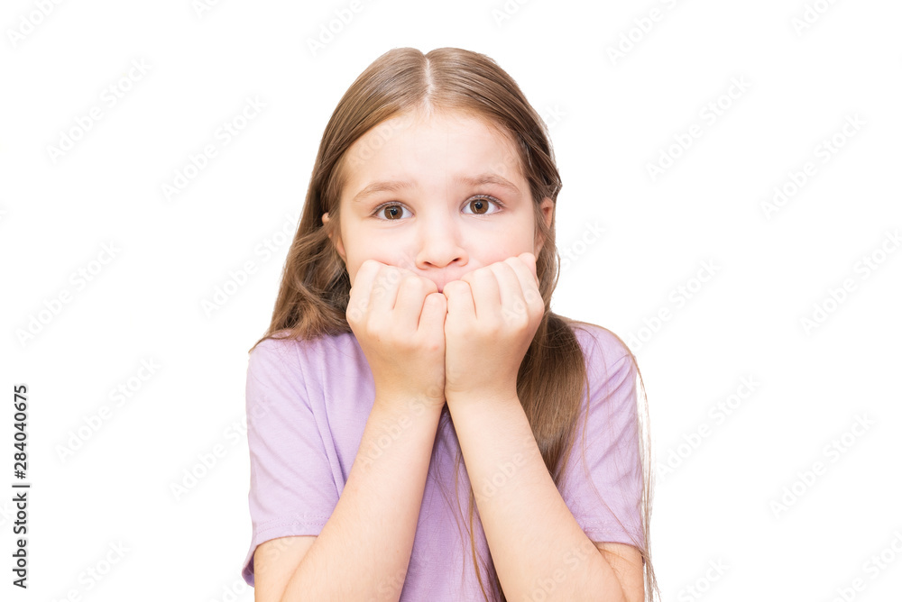 The little girl got scared and put her fists to her face. Isolated on a white background. The little girl got scared and put her fists to her face. Isolated on a white background.