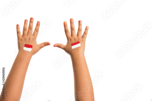 young girls hands only with the Indonesian flag painted on her hands. Holiday event Indonesian independence day concept image with copy space for text.