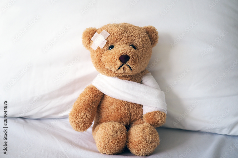 Teddy bear and bandage. Injury concept - obrazy, fototapety, plakaty 