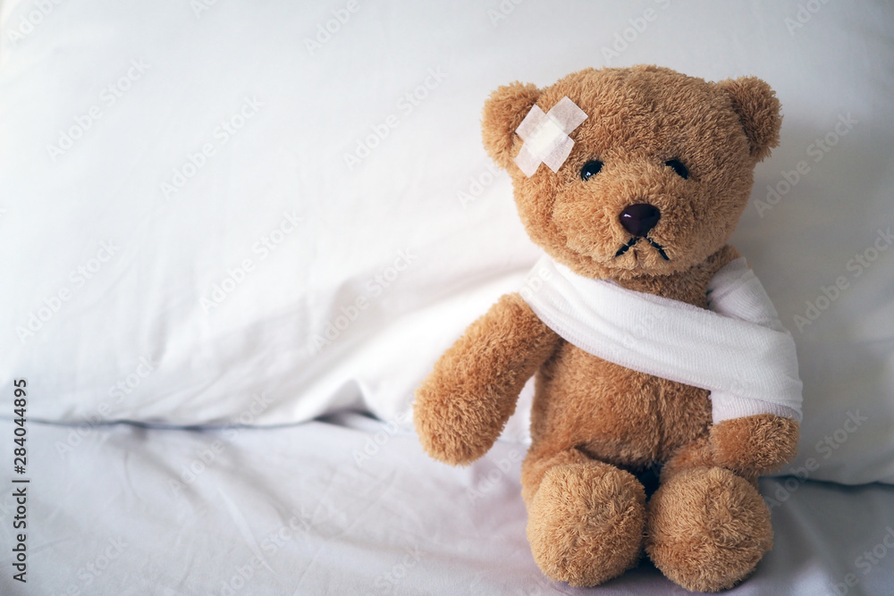 Teddy bear and bandage. Injury concept - obrazy, fototapety, plakaty 