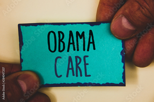 Words writing texts Obama Care. Business concept for Government Program of Insurance System Patient ProtectionMan hold holding turquoise note black letters and frame beige background